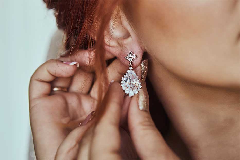 Close up of woman putting in earrings